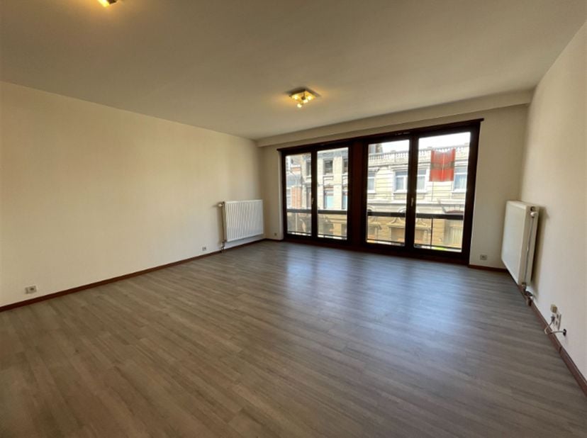 Mooi gelegen studio aan de achterkant van het station van Kortrijk : Ruime living met balkon, ingerichte keuken, badkamer met lavabo, ligbad en toilet