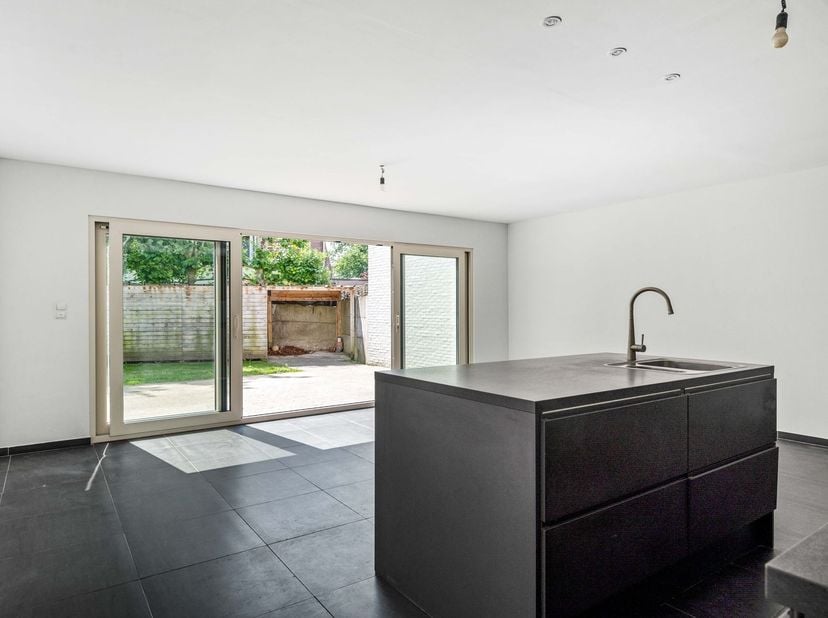 Gezinswoning met 2 slaapkamers (mogelijkheid tot 3) en tuin met carport<br />
Gelijkvloers<br />
Via de inkomhal betreedt u de woning. Aan de voorzi