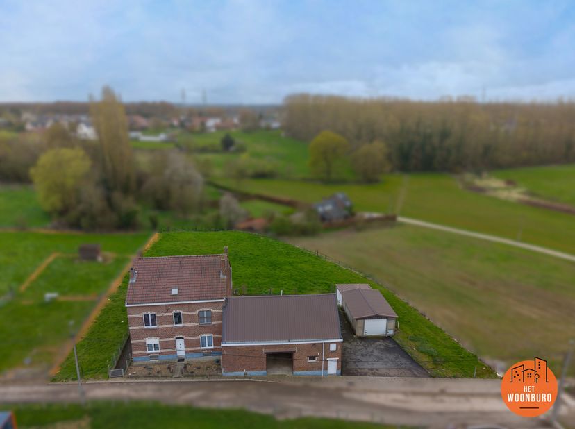Deze uitzonderlijke dubbelwoonst is gelegen op een prachtig perceel van +- 27 are omgeven door velden.<br />
Het pand bestaat uit 2 woningen, een stal