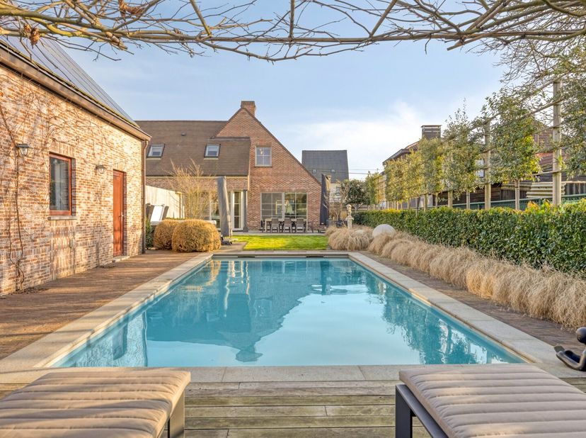 Deze ruime woning is gelegen op een prachtig perceel van 1.474 m² met een praktisch bijgebouw van maar liefst 75 m², een ingebouwd zwembad en een pool