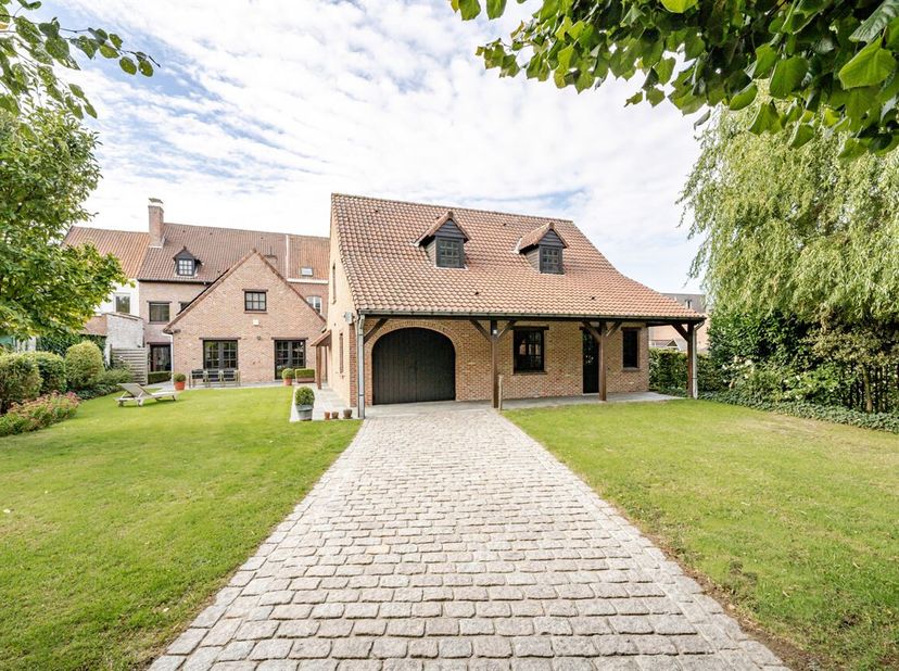 Mooi gelegen, in het centrum van Aalbeke: charmante karaktervolle grote herenwoning met uitweg achteraan (3 garages). <br />
Indeling gelijkvloers: ru