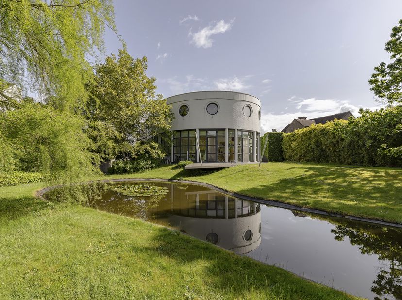 In een groene en residentiële omgeving bevindt zich deze architecturale villa, gekenmerkt door haar ronde vormen, open volumes en grote glaspartijen d