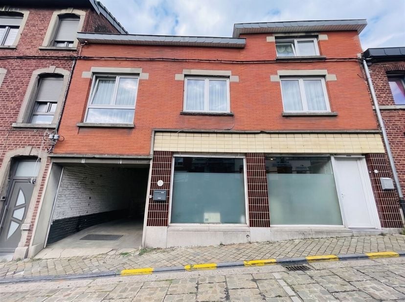 Un immeuble mixte comprenant un appartement deux chambres de 92m2 aux étages et un espace de bureaux (26m2) ainsi que des surfaces de stockage/parking