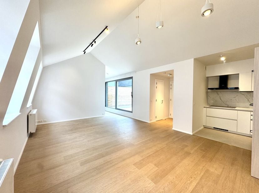 Op 10 minuten lopen van de Grote Markt, een appartement van 86 m² (volgens EPC) op de 2e en bovenste verdieping met lift van een grondig gerenoveerd g
