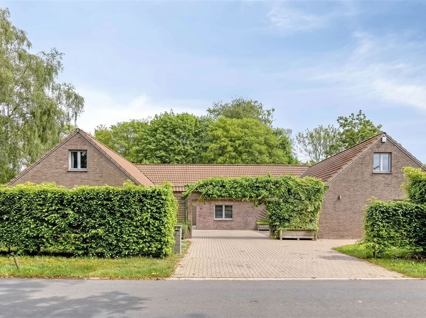 Deze ruime en goed onderhouden woning is gebouwd in 1989. Op het gelijkvloers vindt u een inkomhal met gastentoilet, een ruime lichtrijke woonkamer en