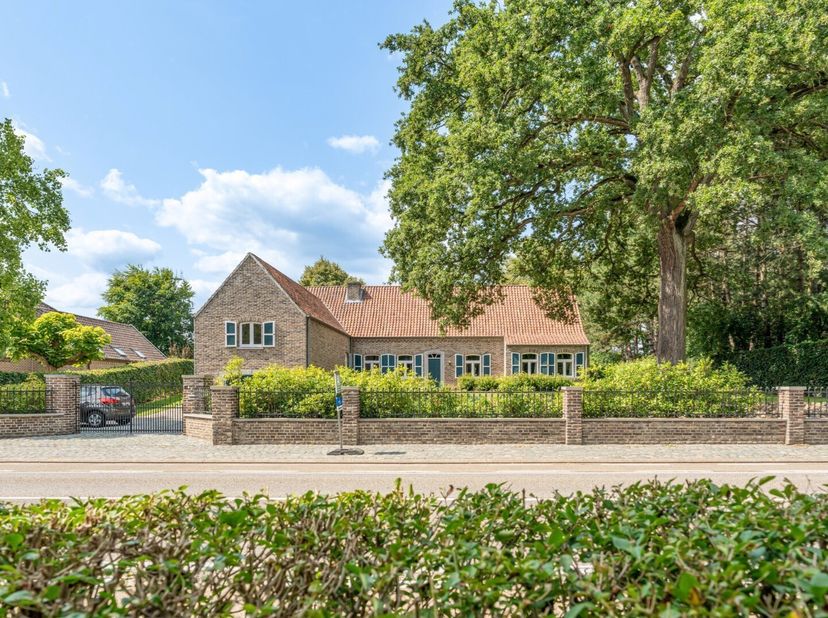 Dit ruime landhuis in een klassieke bouwstijl ademt karakter.  De ligging combineert wonen vlakbij de dorpskern met de rust van een parkachtige tuin.