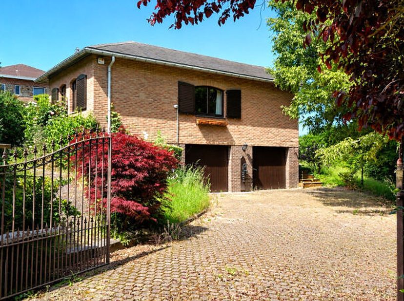 Charmant bungalow demi-niveau (+/- 127m² d'après PEB) 3 chambres avec 2 garages sur une belle parcelle de terrain de 1.093 m² bien situé sur les haute