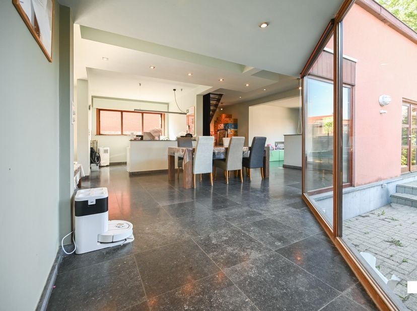 Deze aantrekkelijk gelegen, zeer ruime eengezinswoning met vijf slaapkamers en polyvalente ruimtes, is gelegen op een perceel van 1068 m² en beschikt