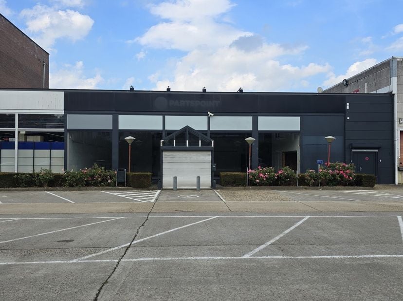 Dit veelzijdige bedrijfspand, gelegen op een uitstekende zichtlocatie langs de Brusselsesteenweg in Herent, combineert representatieve showroomruimte