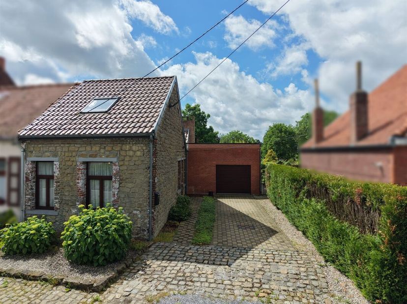 Aantrekkelijk 3-voor-1-kap huis met 2 slaapkamers, garage, terras en beboste tuin; gelegen in het hart van het populaire dorp Ville-Pommeroeul.<br />