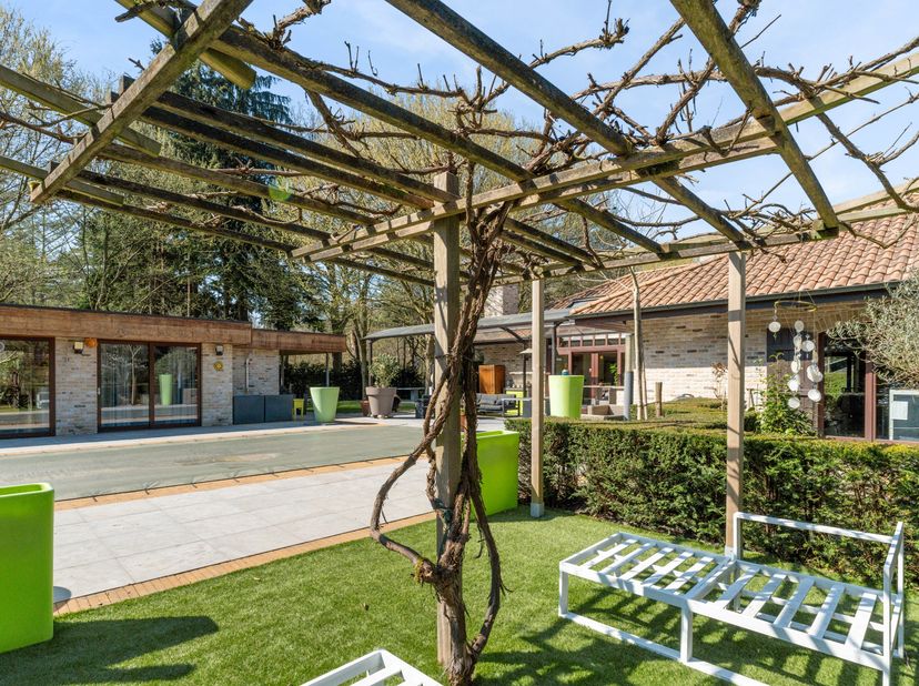 In een rustige en groene omgeving in Schoten bevindt zich deze ruime Spaanse villa op een royaal perceel van 8.670  m². Dit eigendom combineert karakt