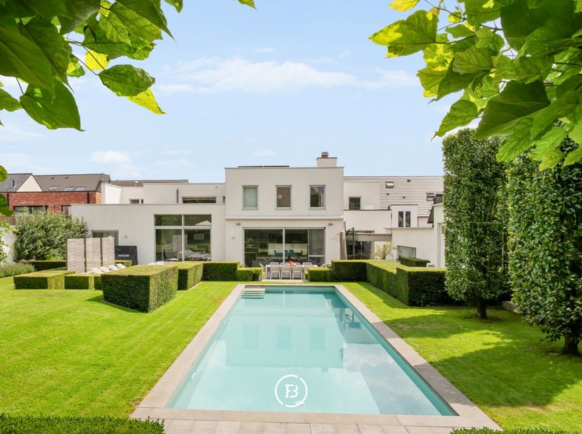 Cette villa contemporaine individuelle est située sur un grand terrain de plus de 1 500 m² et combine des volumes de vie généreux avec un espace profe