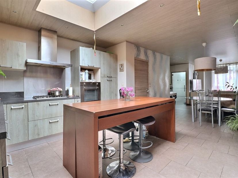 Spacieuse maison de ville comprenant hall d'entrée, séjour avec cuisine équipée ouverte, salle de douche, WC séparé, remise, jardin avec terrasse et a