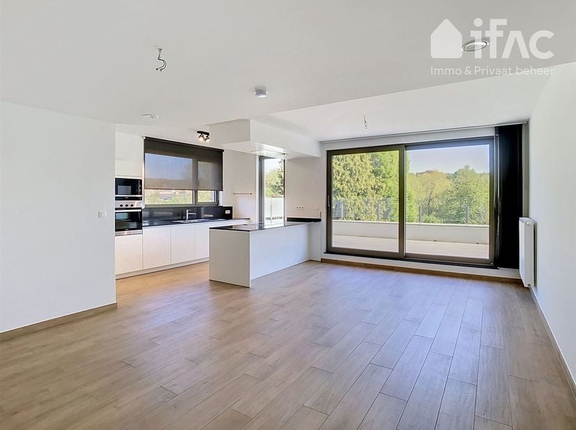 Premier étage : hall d'entrée (10m²) avec toilettes séparées, vaste living (42m²) avec cuisine ouverte entièrement équipée, très grande terrasse (42m²