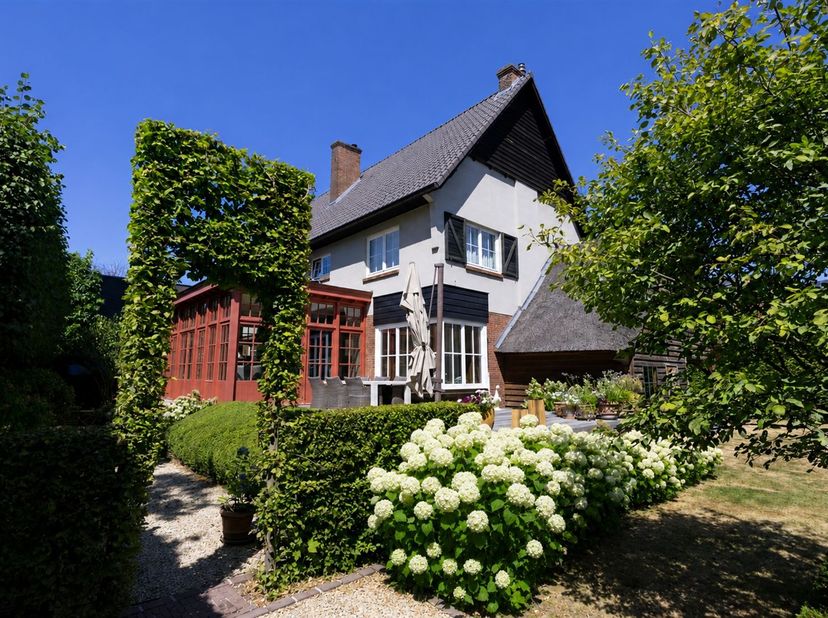 Deze karaktervolle villa in authentieke Engelse cottagestijl werd gebouwd in 1952 en bevindt zich op een volledig aangelegd perceel van circa 6 are 80