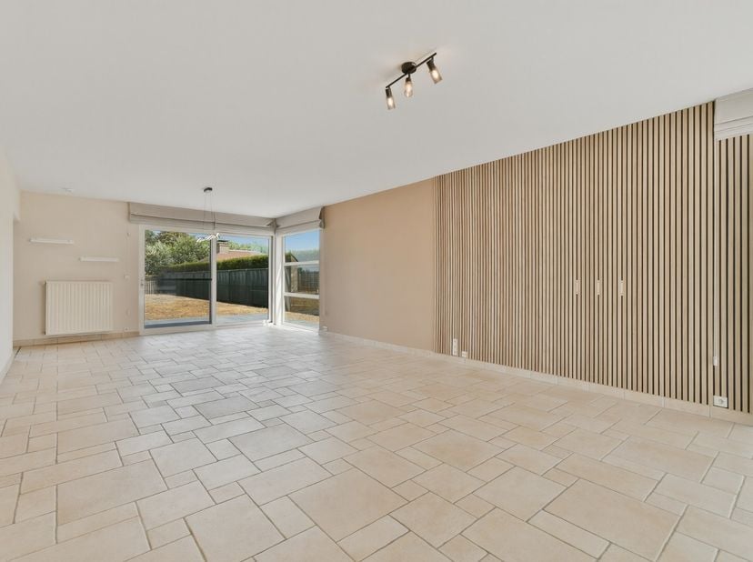 Deze instapklare woning op een perceel van 985 m² biedt volop ruimte en comfort. De lichtrijke leefruimte met schuifraam geeft uit op de tuin met terr