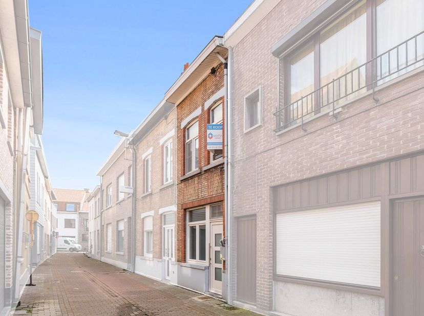 Men komt binnen in de aparte inkomhal die in directe verbinding staat met de woonkamer en open keuken. In de bijbouw bevindt zich de badkamer met bad,