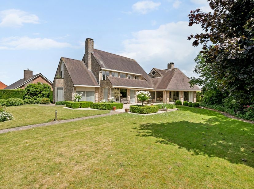 - Villa op een groot hoekperceel (2.510 m²)<br />
- Inkomhal met vestiaire en apart toilet <br />
- Ruime leefruimte met parketvloer en gezellige gash