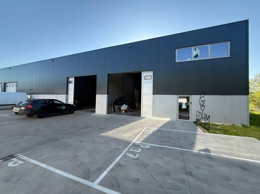 Zeer goed gelegen magazijn te huur (KMO unit) van 550 m² (twee aaneensluitende units met een doorgang ertussen), met mezzanine van 140 m² en 3 parkeer