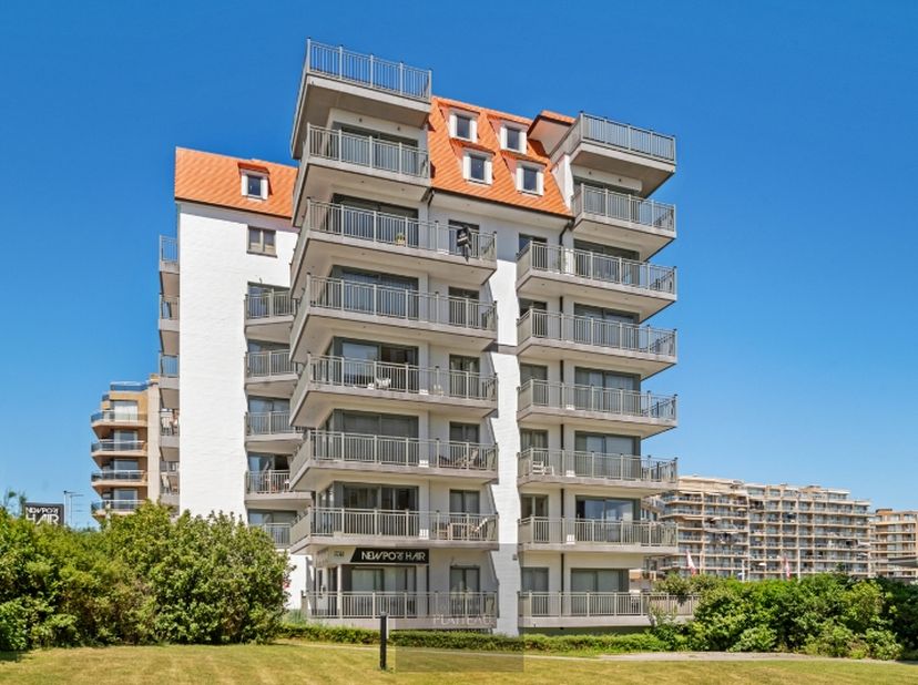 Op een absolute topligging, aan de inkom van Nieuwpoort-Bad, bevindt zich dit lichtrijke hoekappartement op de vijfde verdieping. Dankzij de centrale