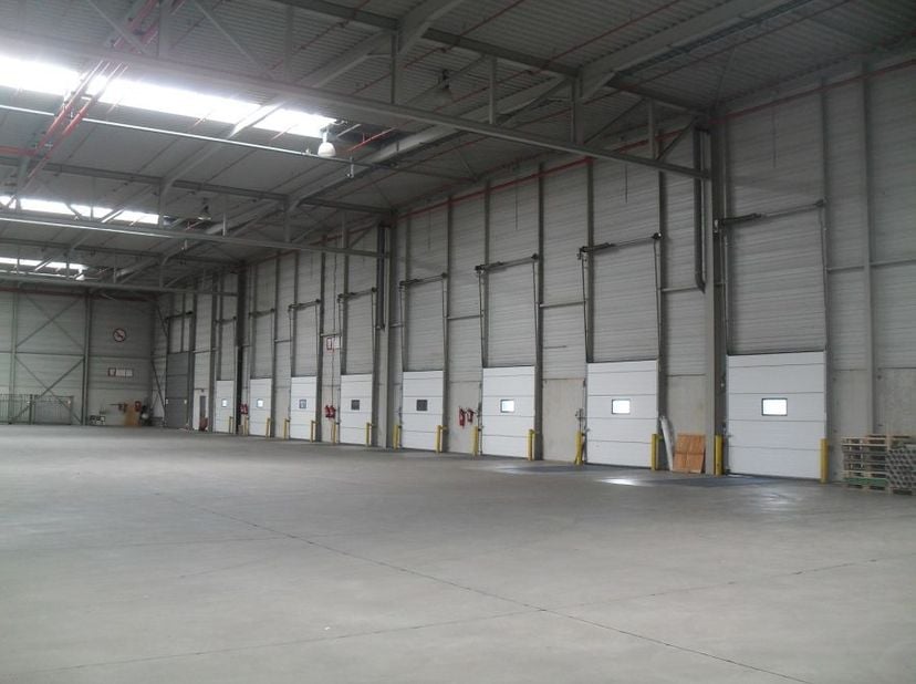 Site logistique à Sint-Niklaas : Stockage et production sur 96 300 m². Stratégiquement situé le long de l’E17 entre Anvers et Gand, incluant quais de
