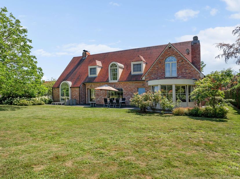 Verzorgde villa, rustig gelegen op 3.126 m² met achteraan open zicht op weilanden. De woning  combineert royale leefruimtes met een warme, charmante a