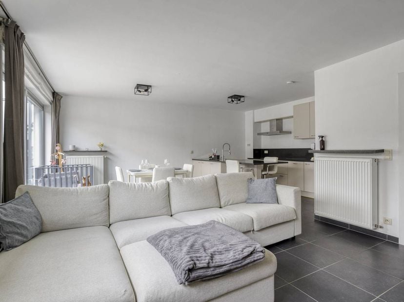 Het appartement omvat een inkomhal met vestiaire en een aparte toilet, een ruime woon- en eetkamer met open en volledig geïnstalleerde keuken, beiden