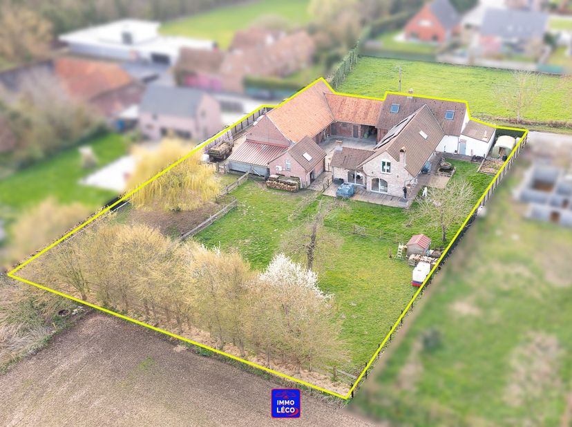 - Première annexe du corps de ferme : Grande habitation familiale desservant un hall d'entrée avec escalier apparent, un WC, un vaste et lumineux séjo