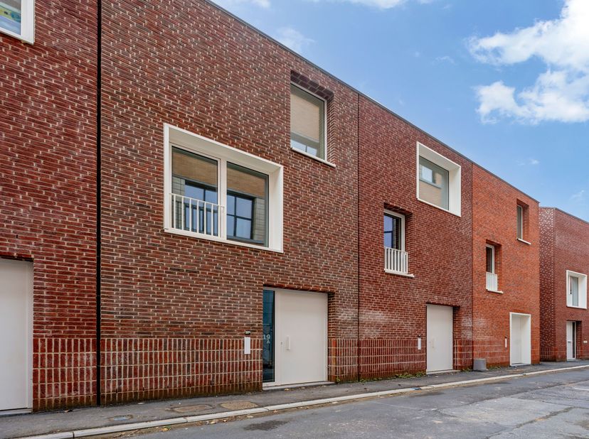 In het centrum van Kortrijk vinden we deze dynamische, splitlevel-stijl woning.<br />
Op het gelijkvloers vinden we een ruime inkomhal met fietsenberg
