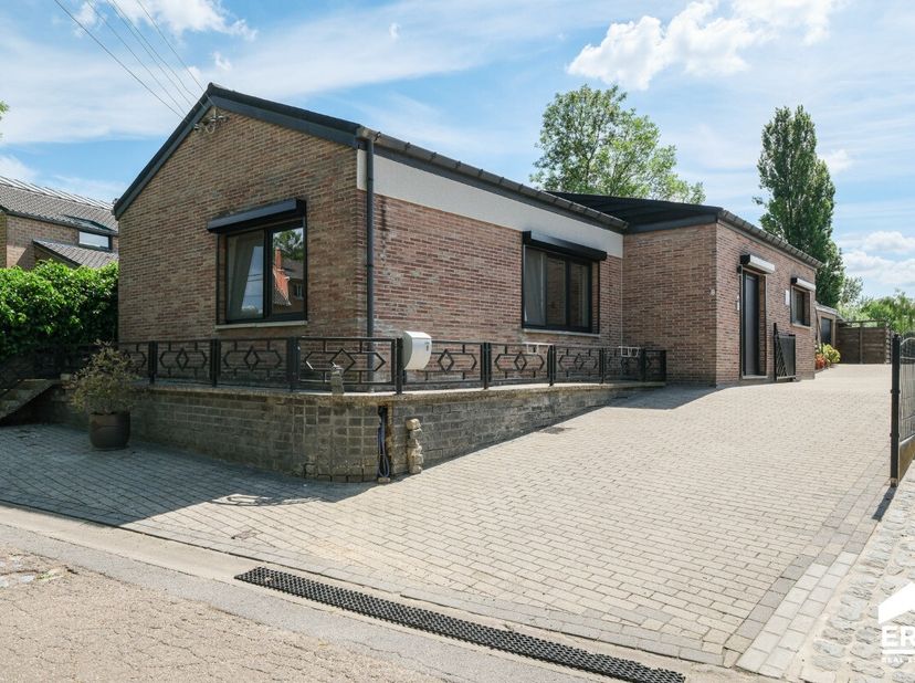 Instapklare gelijkvloerse woning met mooie tuin en tal van mogelijkheden dankzij de ruime garage-werkplaats, rustig en toch centraal gelegen in Sint-T