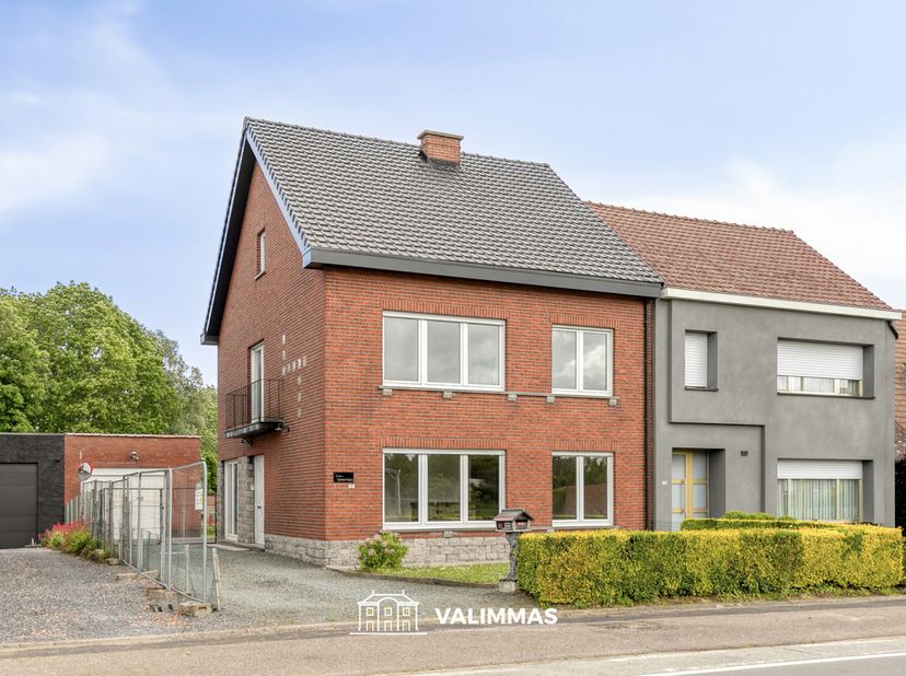 VALIMMAS verkoopt deze ruime en solide driegevelwoning op ± 8 are, met twee garages en een mooie tuin....    <br />
<br />
Het gelijkvloers omvat een