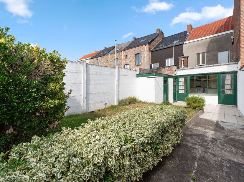 Deze te renoveren rijwoning heeft op het gelijkvloers een woonkamer, keuken, bijkeuken en een toilet. In de achtertuin is er een grote werkplaats van
