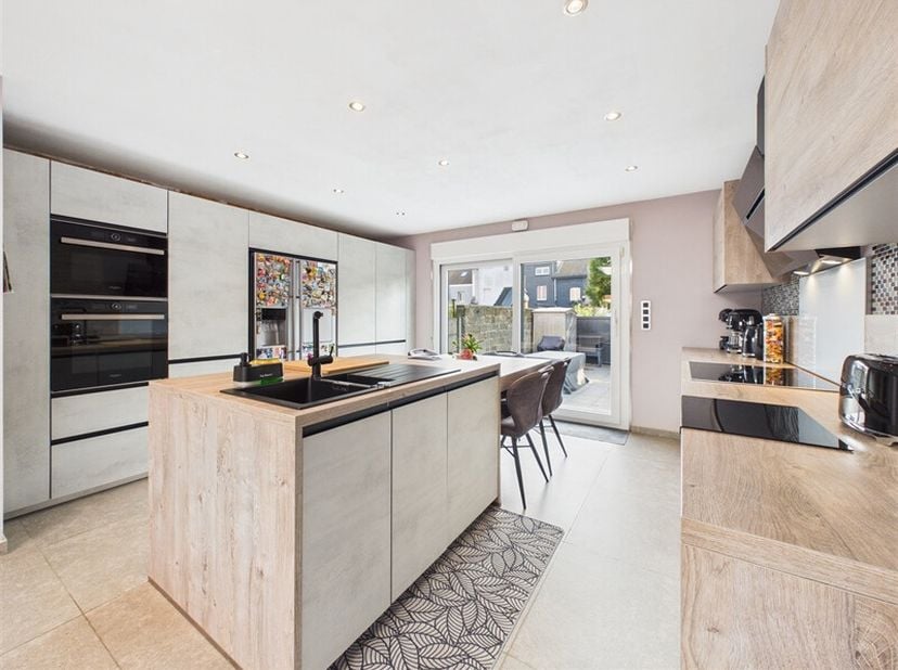 Dès le rez-de-chaussée, la maison vous accueille par un hall d'entrée qui s'ouvre sur un vaste living de plus de 32 m².<br />
Dans son prolongement, u
