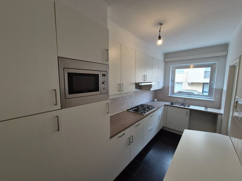 Dit gelijkvloers appartement op wandelafstand van het stadscentrum bestaat uit een ruime living, keuken met kasten, enkele afwasbak en dampkap, badkam