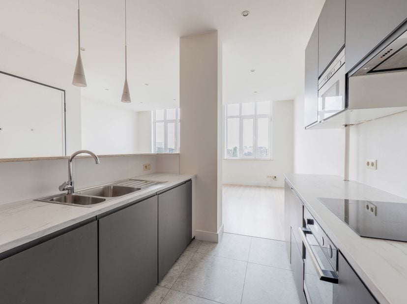 Dit instapklare appartement bevindt zich op de 8ste en hoogste verdieping van een karaktervol modernistisch art-decogebouw en werd recent volledig ger