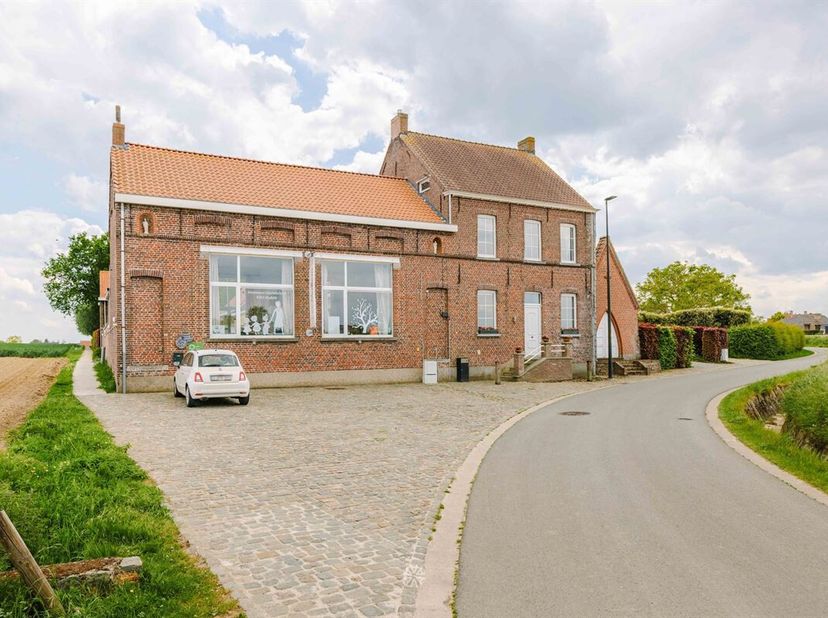 MULLEM - Op een idyllische locatie, omringd door uitgestrekte velden en met zicht op de pittoreske dorpskern van Mullem, bevindt zich dit voormalige s