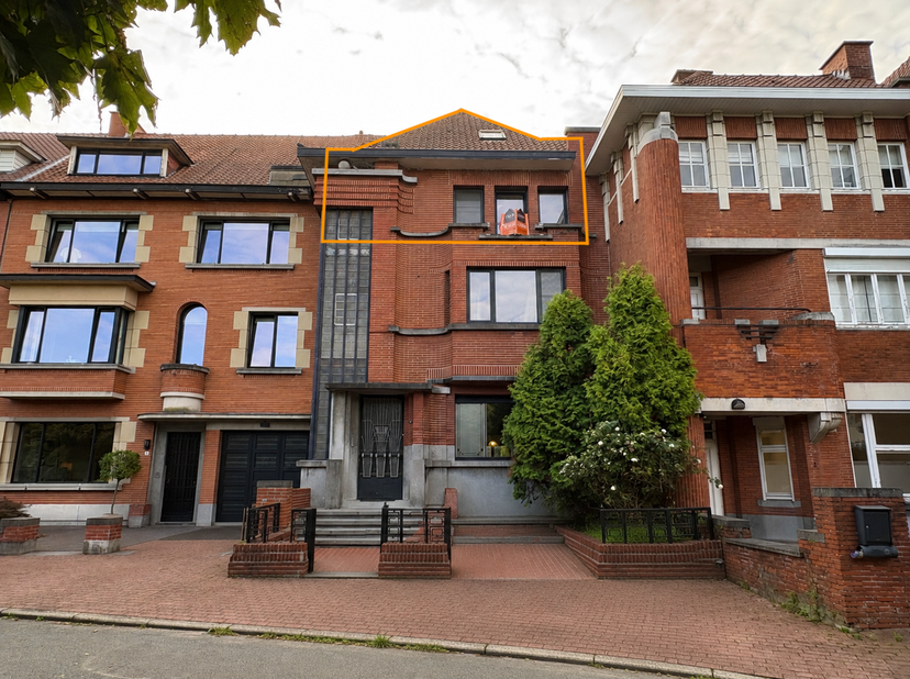 Ce charmant appartement en duplex fait partie d'une maison de maître pleine de caractère et est situé sur la place Jean-Baptiste Mouroit à Ronse. Son