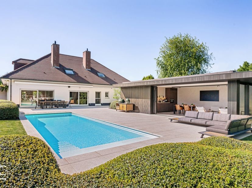 Deze ruime villa is gelegen op een volledig omheind perceel met automatische toegangspoort (Pouleyn) en biedt een sterke combinatie van privacy, comfo