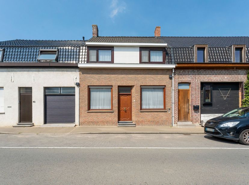 Deze op te frissen woning met ruime garage en uitweg is gelegen in de dorpskern van Watou.<br />
We betreden de woning langs de hal met aansluitend wo