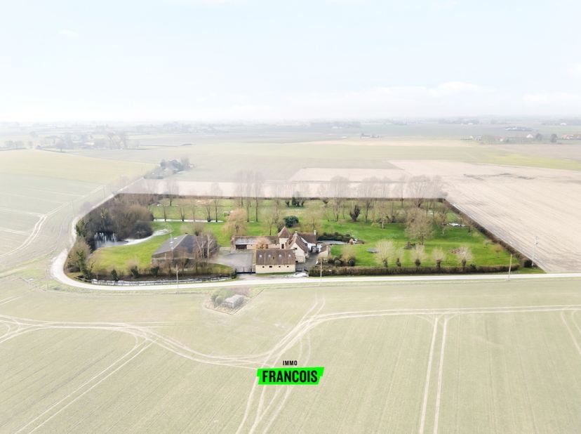 À seulement une pierre lancée de la frontière belge, dans le pittoresque Hondschoote, se trouve cette exceptionnelle ferme-habitation. Située Chemin d