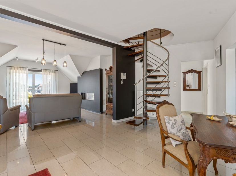 Bij binnenkomst via de inkomhal heb je toegang tot de woonkamer. Het appartement is een oase van licht, met een open, lichtrijke woonkamer die je naar