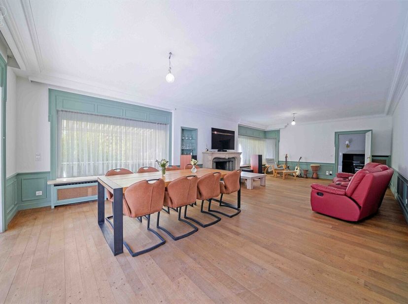 Ruime villa met burgerlijk karakter met op de begane grond twee aparte ingangen, een ruime woonkamer met open haard, een ingerichte keuken, een douche