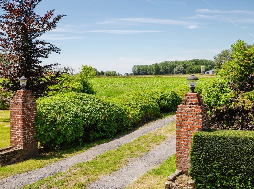 LIGGING<br />
Deze karaktervolle hoeve geniet van een rustige en landelijke ligging te Poesele, een charmante deelgemeente van Deinze. Omgeven door ui