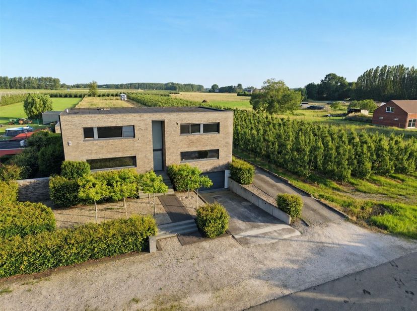 Via de inkomhal, met een ruime berging en gastentoilet, betreedt u de leefruimte. Deze bestaat uit een open en lichtrijke living/zithoek met gashaard,