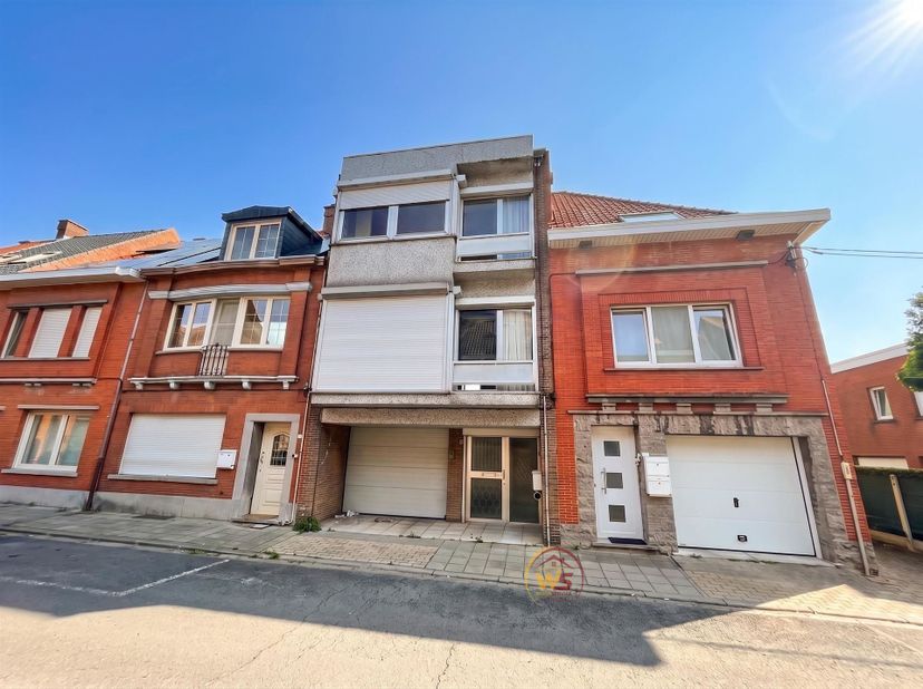 Zeer ruime en sterk gebouwde woning met grote garage, 3 slaapkamers en mooie tuin. Gelijkvloers: inkomhal, grote garage, achtergelegen berging, stookp