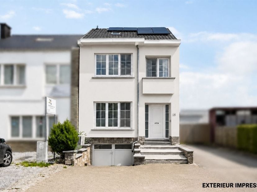 Gerenoveerde halfopen woning met drie slaapkamers, garage, zonnepanelen en een volledig afgewerkte zolder, gelegen nabij het centrum van Sint-Truiden.