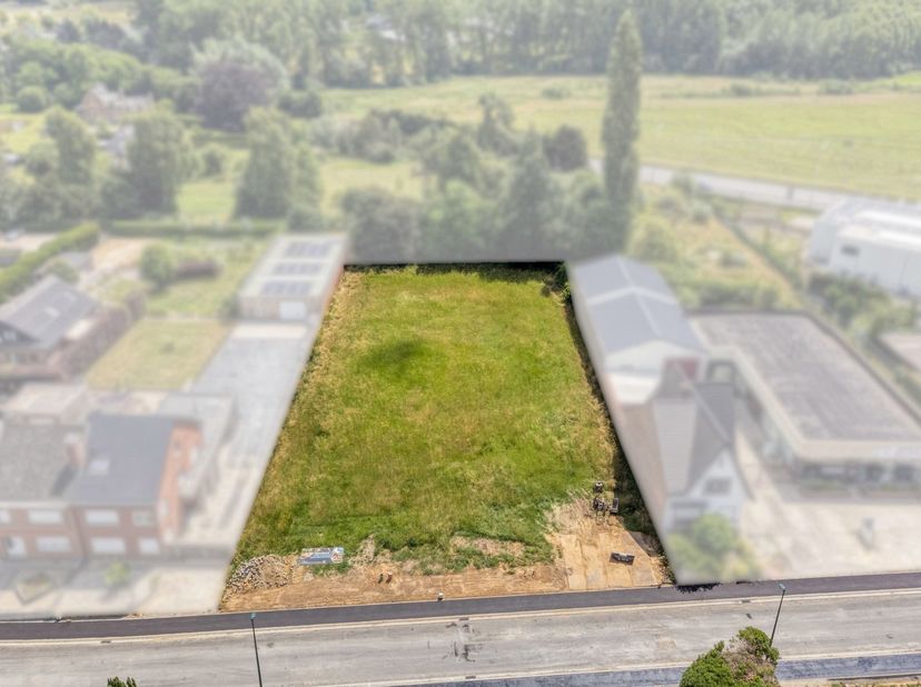 Dit perceel van 827 m² is ideaal gelegen in een groene en rustige omgeving te Roosdaal. U geniet er van een aangename woonomgeving met een vlotte verb