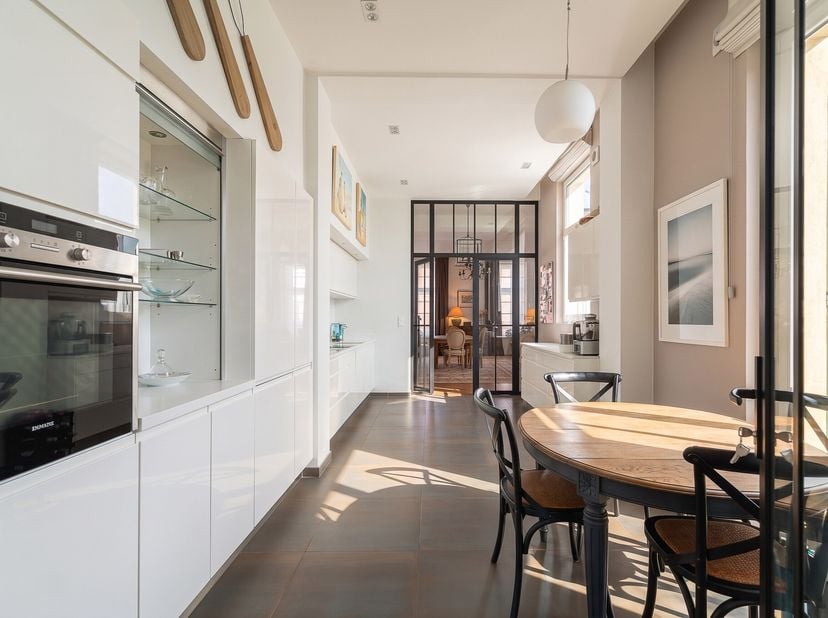 À quelques pas de la Grand-Place de Tournai, dans l'atmosphère préservée de l'ancien Couvent des Dominicains, cet appartement de plain-pied développe