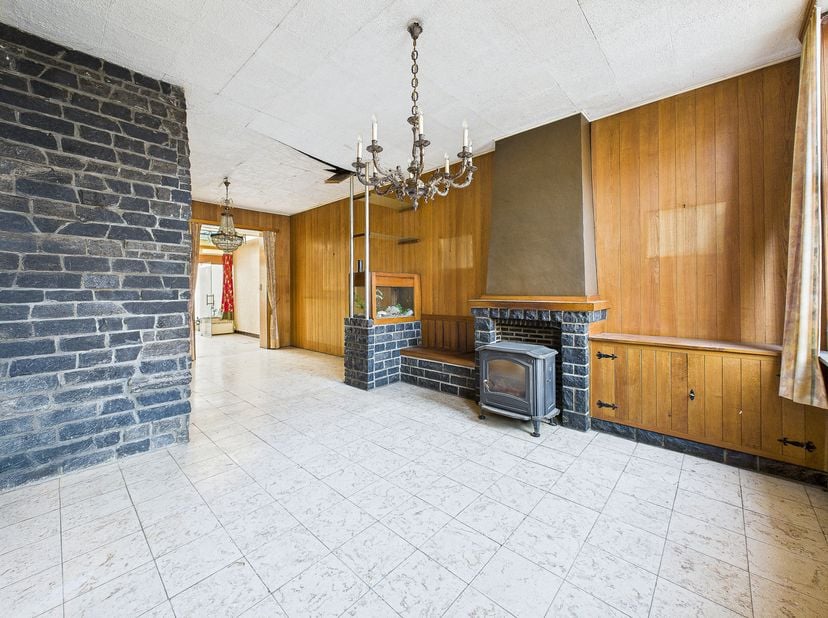 Au rez-de-chaussée : un hall d'entrée desservant un vaste séjour lumineux de +/- 35 m², une véranda offrant une belle vue et un accès direct sur le ja
