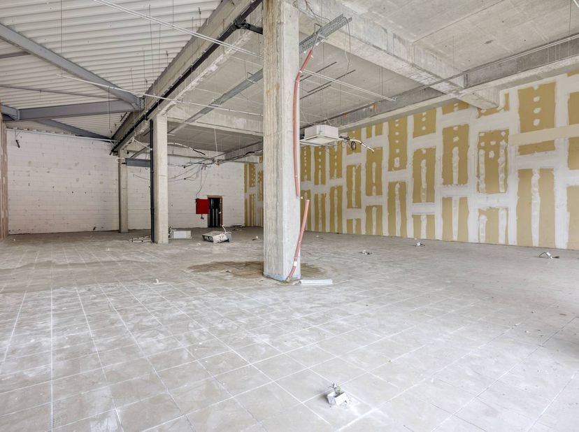 Dit ruime handelspand van ca. 425 m² is gelegen in een goed bereikbaar en commercieel aantrekkelijk shoppingcenter in Maaseik, waar het geniet van een